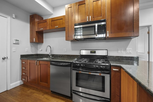3316 W Byron St Unit 1, Chicago, IL 60618 - kitchen featuring stainless steel appliances, dark wood-type flooring, dark stone counters, and brown cabinets