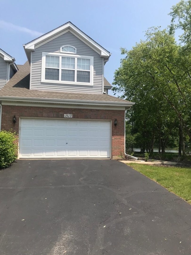 1317 Leonard Dr, Schaumburg, IL 60193 - traditional home with brick siding, driveway, a garage, and a shingled roof
