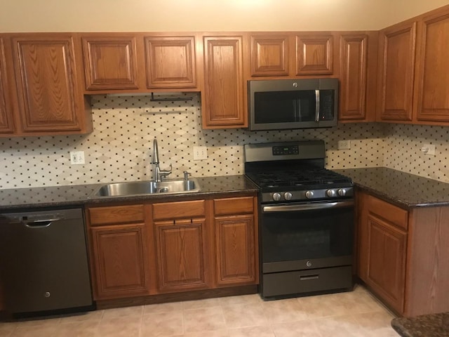 1317 Leonard Dr, Schaumburg, IL 60193 - kitchen featuring appliances with stainless steel finishes, brown cabinetry, backsplash, and dark stone countertops