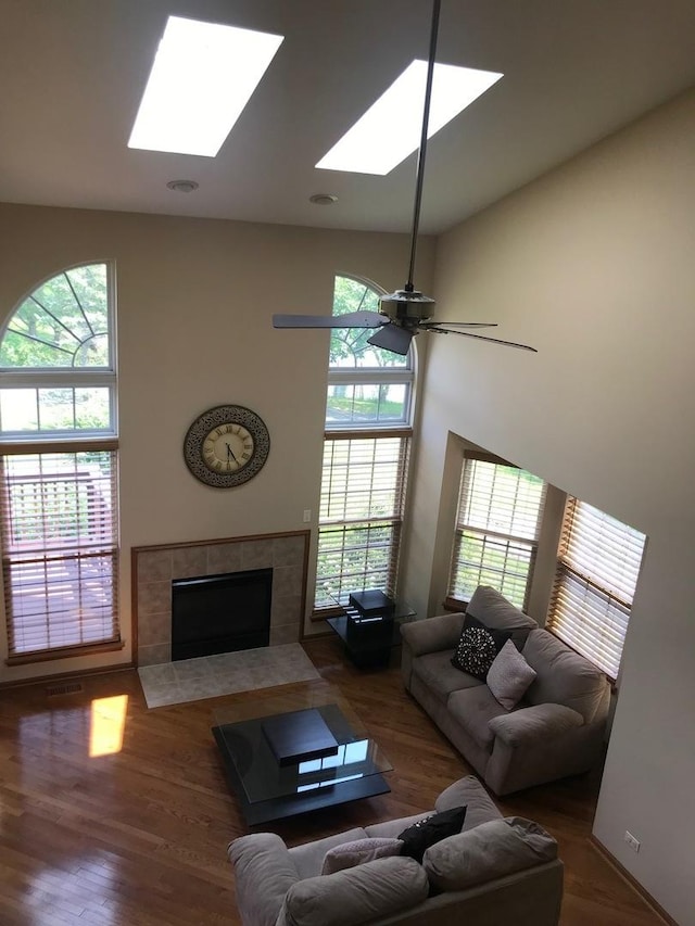 1317 Leonard Dr, Schaumburg, IL 60193 - living area featuring a skylight, a fireplace, a ceiling fan, and wood finished floors