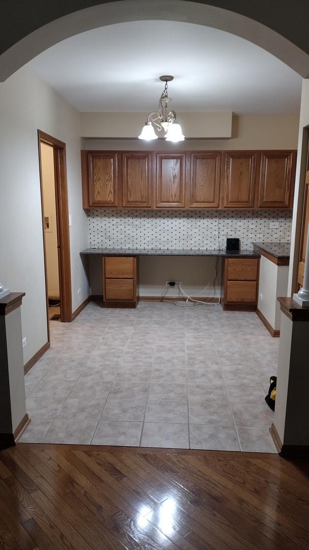 1317 Leonard Dr, Schaumburg, IL 60193 - kitchen featuring arched walkways, brown cabinets, and built in study area