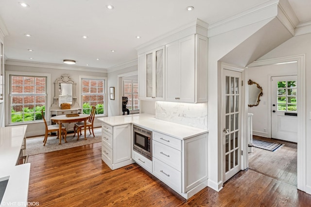 3233 Park Pl, Evanston, IL 60201 - kitchen featuring stainless steel microwave, light countertops, white cabinetry, hardwood / wood-style flooring, and crown molding