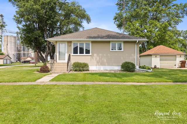 301 N Second St, Ashkum, IL 60911 - view of front facade with a front yard, a garage, and an outbuilding