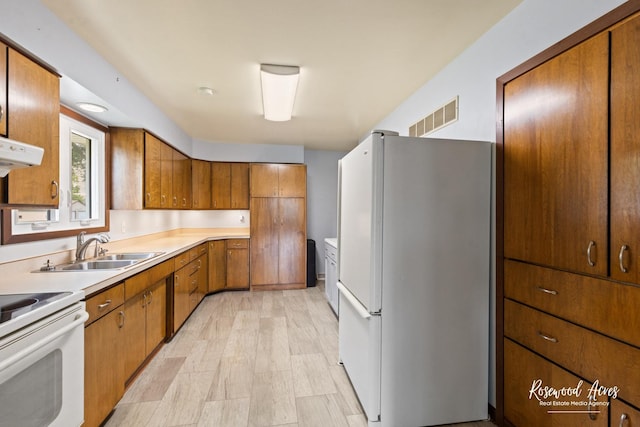 301 N Second St, Ashkum, IL 60911 - kitchen with white appliances, brown cabinets, light countertops, and range hood