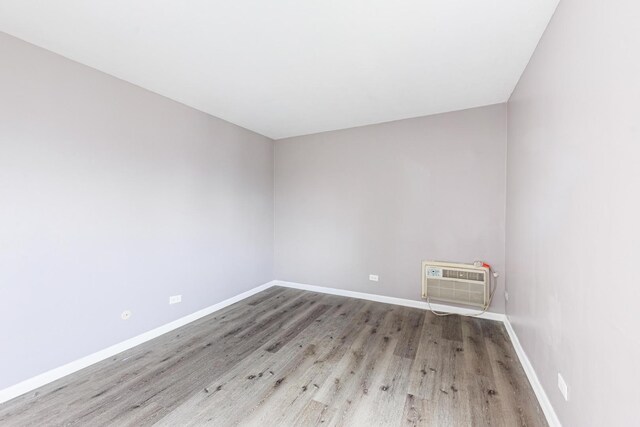 9516 S Kildare Ave Unit 2N, Oak Lawn, IL 60453 - empty room featuring an AC wall unit and wood finished floors
