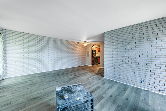 9516 S Kildare Ave Unit 2N, Oak Lawn, IL 60453 - unfurnished living room featuring brick wall, arched walkways, wood finished floors, and a ceiling fan