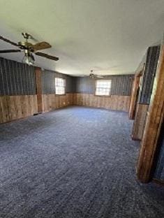 1406 Searle Dr, Normal, IL 61761 - unfurnished living room with dark colored carpet, wainscoting, and wood walls
