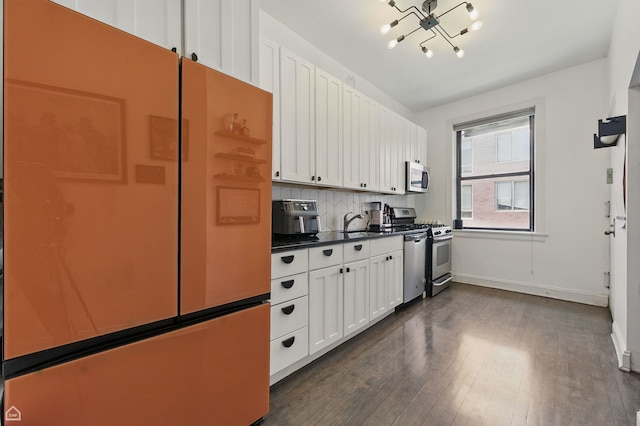 726 W Sheridan Rd Unit 3S, Chicago, IL 60613 - kitchen featuring stainless steel appliances, dark wood finished floors, a chandelier, dark countertops, and white cabinetry