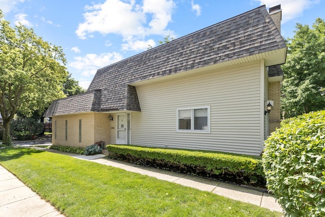 221 Pin Oak Dr, Wilmette, IL 60091 - front facade featuring a shingled roof, brick siding, mansard roof, and a front lawn