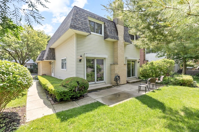 221 Pin Oak Dr, Wilmette, IL 60091 - back of property featuring roof with shingles, mansard roof, a lawn, a patio, and brick siding