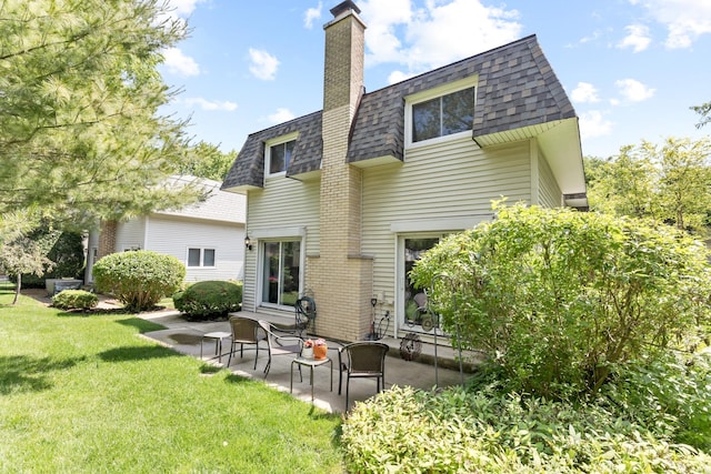 221 Pin Oak Dr, Wilmette, IL 60091 - rear view of property with a shingled roof, a patio area, a yard, a chimney, and mansard roof