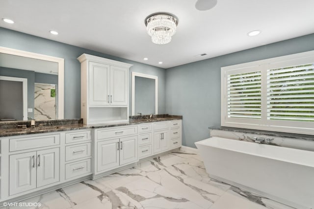411 S Berkley Ave, Elmhurst, IL 60126 - bathroom featuring double vanity, a freestanding bath, marble look tile flooring, recessed lighting, and a chandelier
