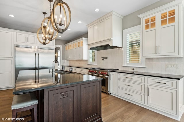 411 S Berkley Ave, Elmhurst, IL 60126 - kitchen featuring high end appliances, a chandelier, wood finished floors, tasteful backsplash, and a kitchen bar