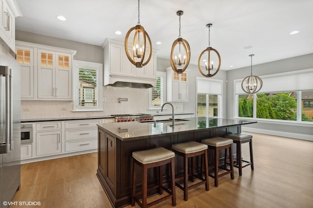 411 S Berkley Ave, Elmhurst, IL 60126 - kitchen with a chandelier, wood finished floors, tasteful backsplash, glass insert cabinets, and white cabinetry
