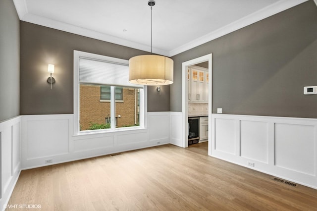 411 S Berkley Ave, Elmhurst, IL 60126 - unfurnished dining area featuring wainscoting, light wood finished floors, a decorative wall, ornamental molding, and beverage cooler