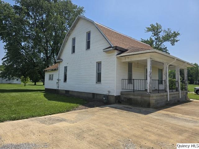 200 S Gillham, West Point, IL 62380 - dutch colonial featuring a porch, a front yard, and roof with shingles