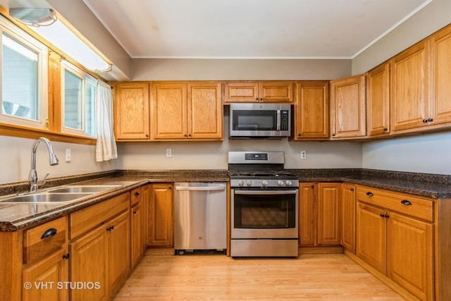 812 S Center St, Plano, IL 60545 - kitchen featuring stainless steel appliances, light wood-style floors, crown molding, and brown cabinets