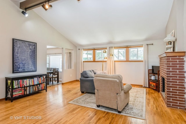 812 S Center St, Plano, IL 60545 - living area with track lighting, wood finished floors, lofted ceiling, and a fireplace