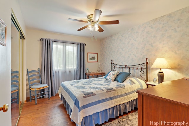 27892 W Bayview Dr, Ingleside, IL 60041 - bedroom with wallpapered walls, a closet, wood-type flooring, and a ceiling fan