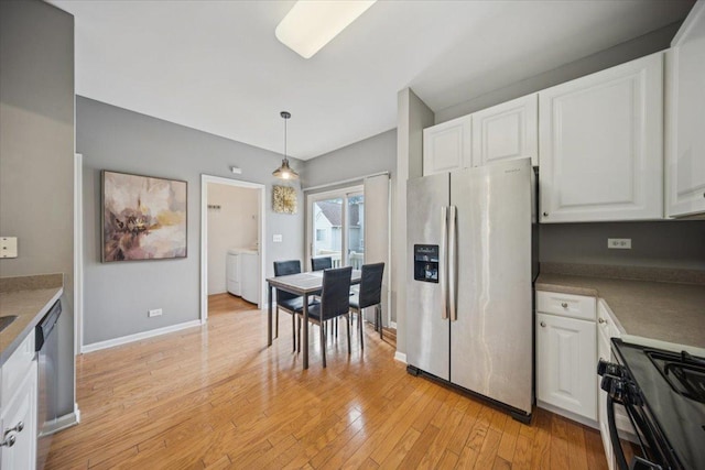 180 New Haven Dr, Cary, IL 60013 - kitchen featuring stainless steel fridge with ice dispenser, black gas stove, white cabinets, light wood-style floors, and washer and clothes dryer