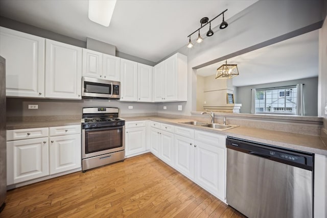 180 New Haven Dr, Cary, IL 60013 - kitchen with stainless steel appliances, light wood-style flooring, white cabinets, and a chandelier
