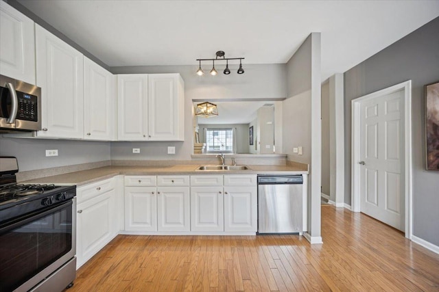 180 New Haven Dr, Cary, IL 60013 - kitchen featuring appliances with stainless steel finishes, light countertops, light wood-type flooring, and white cabinetry