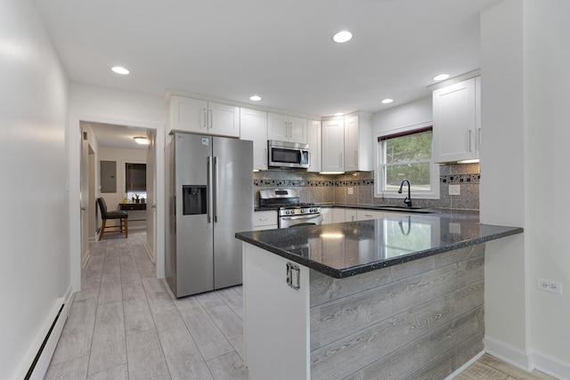 550 N Center St, South Elgin, IL 60177 - kitchen with appliances with stainless steel finishes, a baseboard heating unit, dark stone counters, white cabinets, and recessed lighting