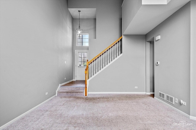 114 Devoe Dr N, Oswego, IL 60543 - stairway featuring a chandelier, carpet flooring, and a high ceiling