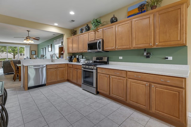11692 Sunderlin Dr, Huntley, IL 60142 - kitchen with stainless steel appliances, a peninsula, light countertops, a ceiling fan, and recessed lighting