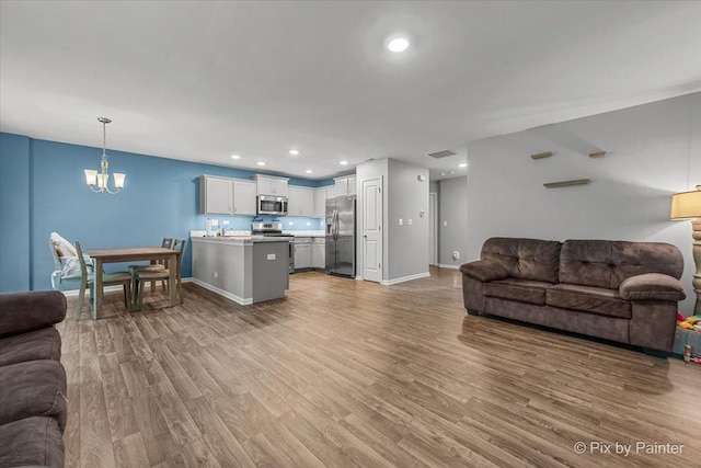 1141 Westlake Dr, Cary, IL 60013 - living room with wood finished floors, a chandelier, and recessed lighting