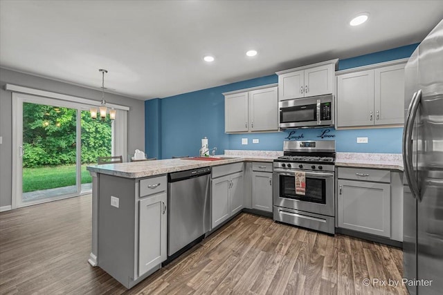 1141 Westlake Dr, Cary, IL 60013 - kitchen featuring stainless steel appliances, a peninsula, gray cabinets, a chandelier, and dark wood-style flooring