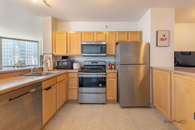 222 N Columbus Dr Unit 912, Chicago, IL 60601 - kitchen featuring appliances with stainless steel finishes, light brown cabinetry, light countertops, light tile patterned floors, and a textured ceiling
