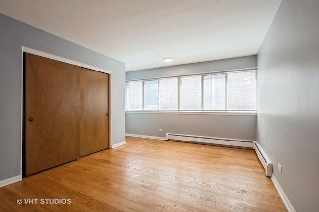 200 Ridge Ave Unit 2C, Evanston, IL 60202 - unfurnished bedroom with wood finished floors, baseboard heating, and a closet