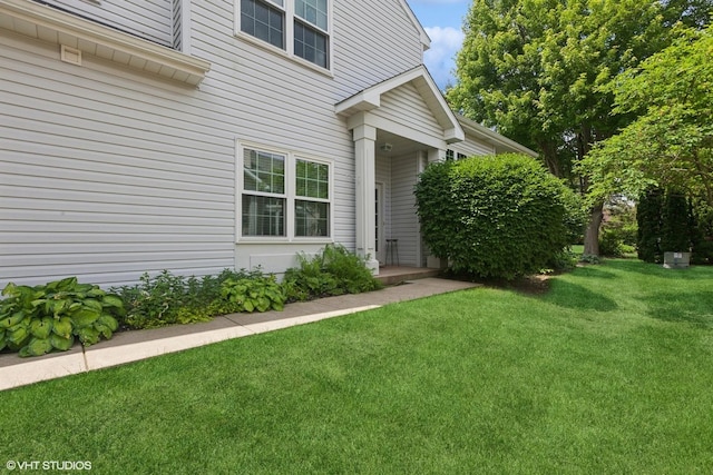 view of exterior entry with a yard