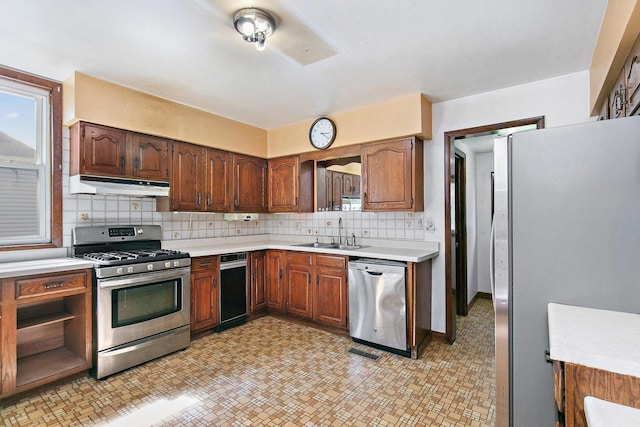300 Stone St, South Elgin, IL 60177 - kitchen featuring stainless steel appliances, under cabinet range hood, light countertops, decorative backsplash, and brown cabinetry