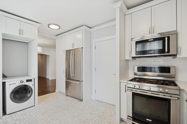 1640 E 50th St Unit 13B, Chicago, IL 60615 - kitchen featuring stainless steel appliances, washer / clothes dryer, light countertops, white cabinets, and decorative backsplash