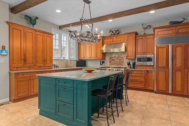1005 Hiawatha Ln, Riverwoods, IL 60015 - kitchen featuring under cabinet range hood, built in appliances, beamed ceiling, a kitchen island, and backsplash