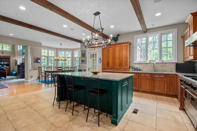 1005 Hiawatha Ln, Riverwoods, IL 60015 - kitchen featuring a chandelier, beam ceiling, range with two ovens, healthy amount of natural light, and a kitchen island