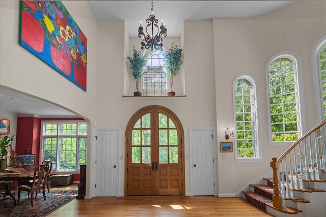 1005 Hiawatha Ln, Riverwoods, IL 60015 - foyer entrance featuring a towering ceiling, wood finished floors, stairway, a chandelier, and arched walkways