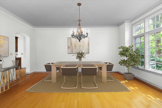 1005 Hiawatha Ln, Riverwoods, IL 60015 - dining area featuring arched walkways, wood finished floors, healthy amount of natural light, ornamental molding, and a chandelier