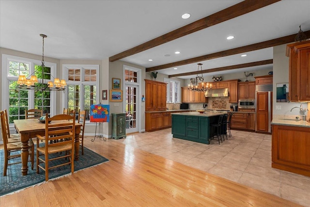 1005 Hiawatha Ln, Riverwoods, IL 60015 - kitchen featuring a chandelier, under cabinet range hood, a center island, built in appliances, and beam ceiling