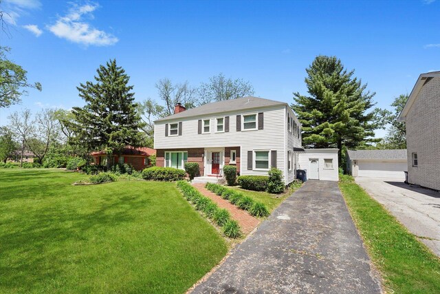 255 Irving Blvd, Chicago Heights, IL 60411 - view of front of house featuring a chimney, a front lawn, an outbuilding, and a garage