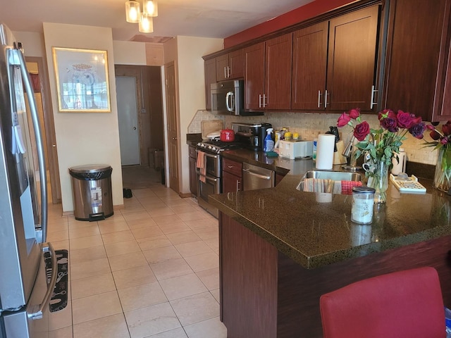 18324 Pond View Ct, Tinley Park, IL 60477 - kitchen featuring appliances with stainless steel finishes, light tile patterned floors, a peninsula, and decorative backsplash