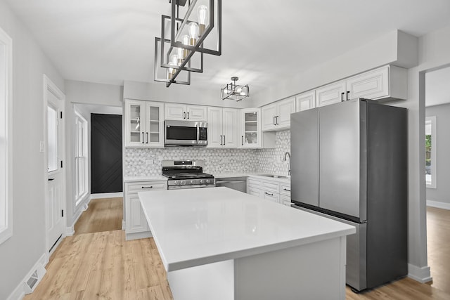 232 S Walnut St, Glenwood, IL 60425 - kitchen featuring stainless steel appliances, a chandelier, light countertops, tasteful backsplash, and white cabinetry