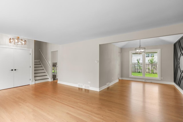 232 S Walnut St, Glenwood, IL 60425 - unfurnished living room with a chandelier, stairway, and light wood-style flooring