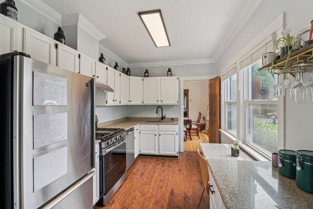837 Wesley Ave, Oak Park, IL 60304 - kitchen featuring appliances with stainless steel finishes, under cabinet range hood, light stone countertops, ornamental molding, and white cabinetry
