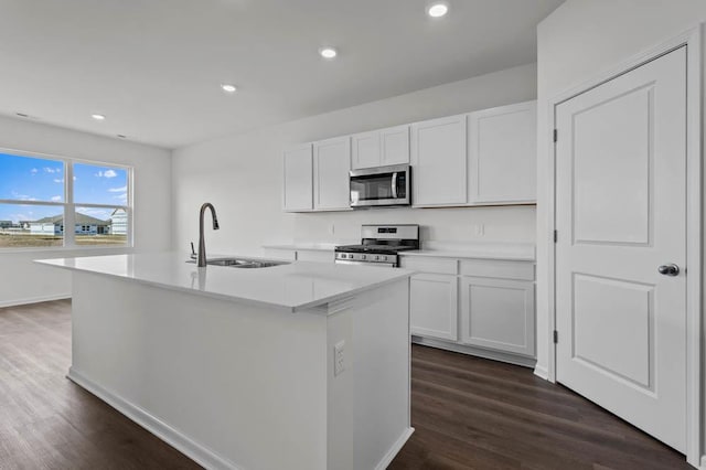 9900 Humbolt St, Huntley, IL 60142 - kitchen featuring appliances with stainless steel finishes, white cabinets, a kitchen island with sink, dark wood finished floors, and light countertops