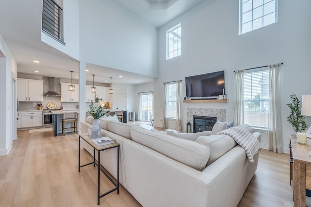 25320 W Alison Rd, Plainfield, IL 60586 - living area featuring healthy amount of natural light, a high ceiling, a fireplace, light wood finished floors, and recessed lighting