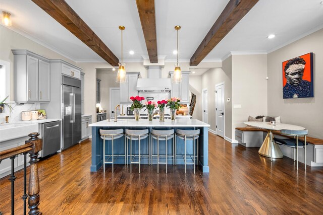 4741 S Drexel Blvd, Chicago, IL 60615 - kitchen with stainless steel appliances, light countertops, dark wood-type flooring, beamed ceiling, and custom range hood