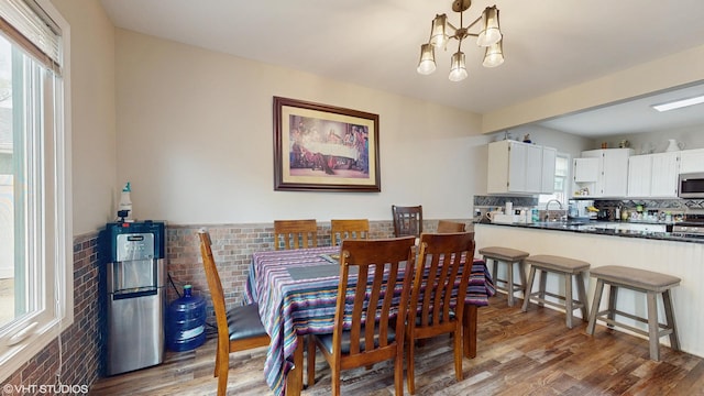 354 Millard Ave, Crystal Lake, IL 60014 - dining area featuring brick wall, wood finished floors, and a chandelier